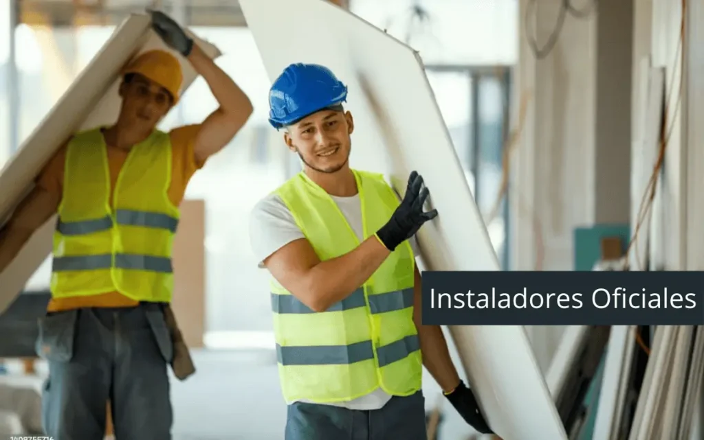 Equipo de instaladores oficiales de paneles de drywall en plena obra, llevando materiales con equipo de seguridad.